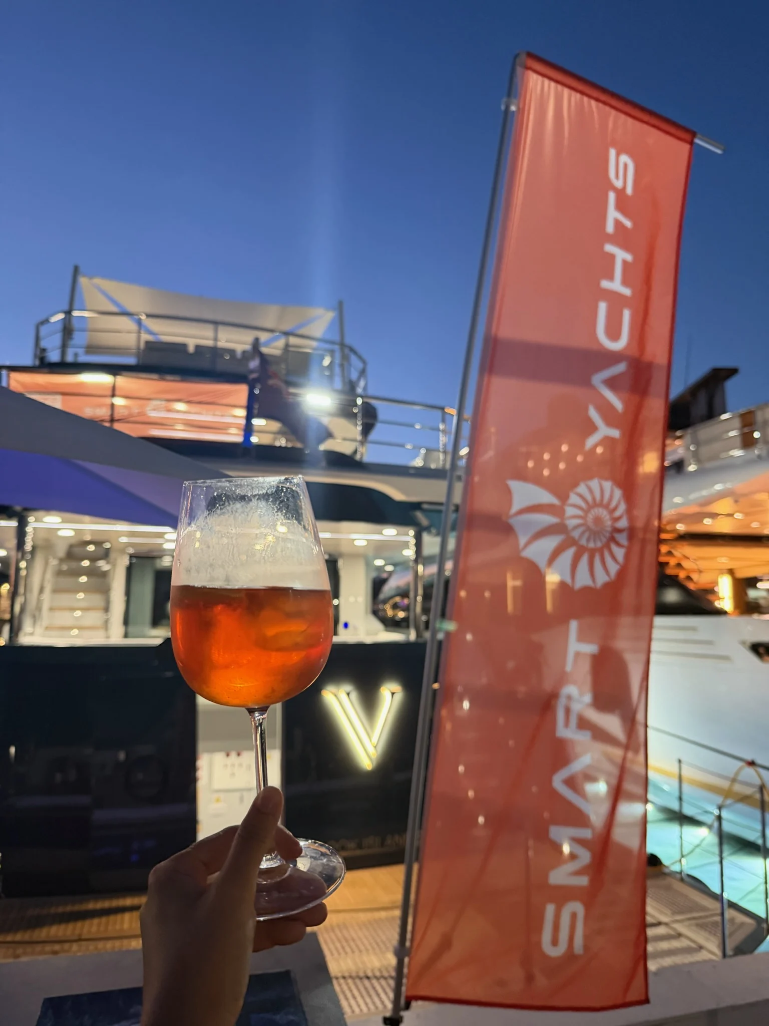 A toast on board M/Y V beside the Smart Yachts flag